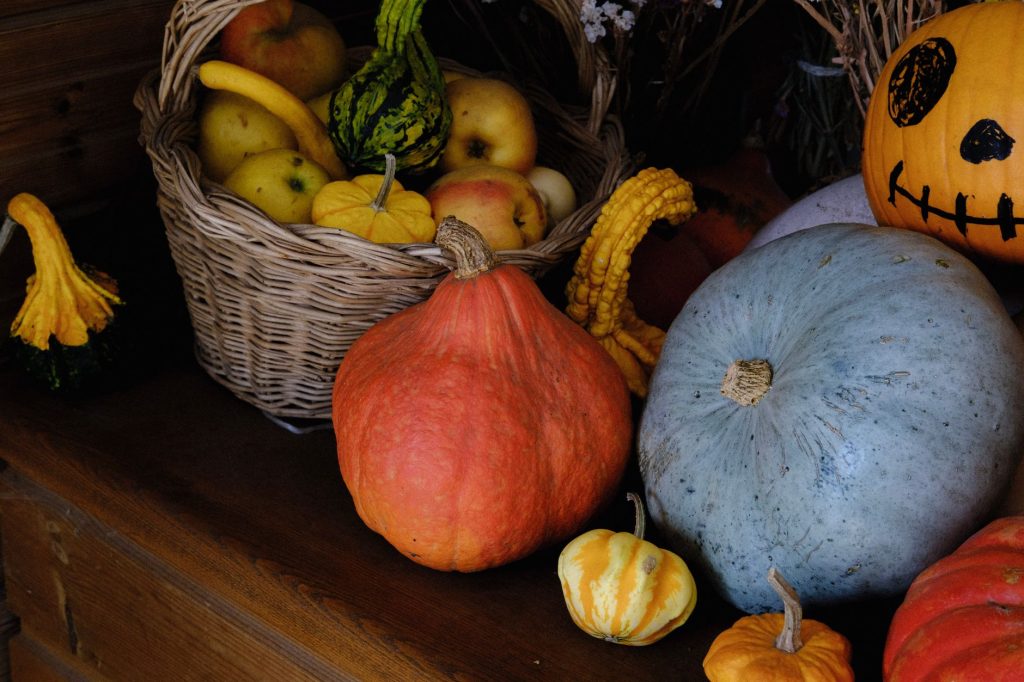Вітаміни восени: як підтримати організм у сезон A vibrant assortment of autumn harvest fruits and gourds displayed with a basket of apples.