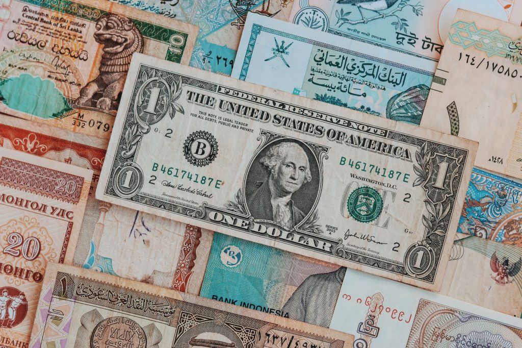 Як працює курс валют і від чого він залежить Top view of assorted paper money with American greenback representing image of President and numbers with words and signature on bill