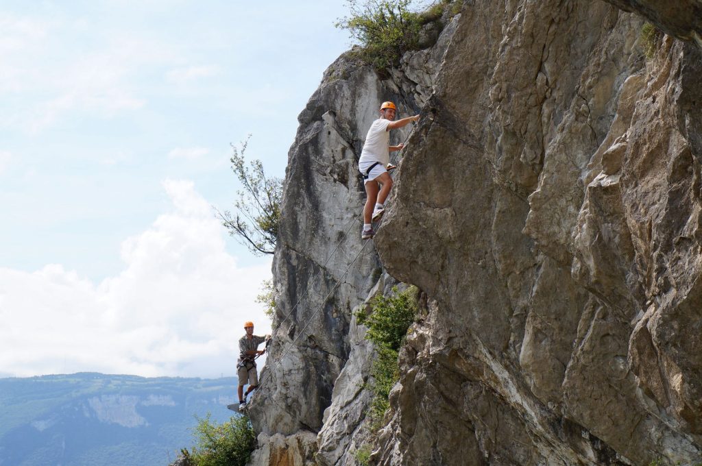 Скелелазіння для початківців: види та перші кроки Two climbers ascend a rugged cliff, showcasing adventure and skill.