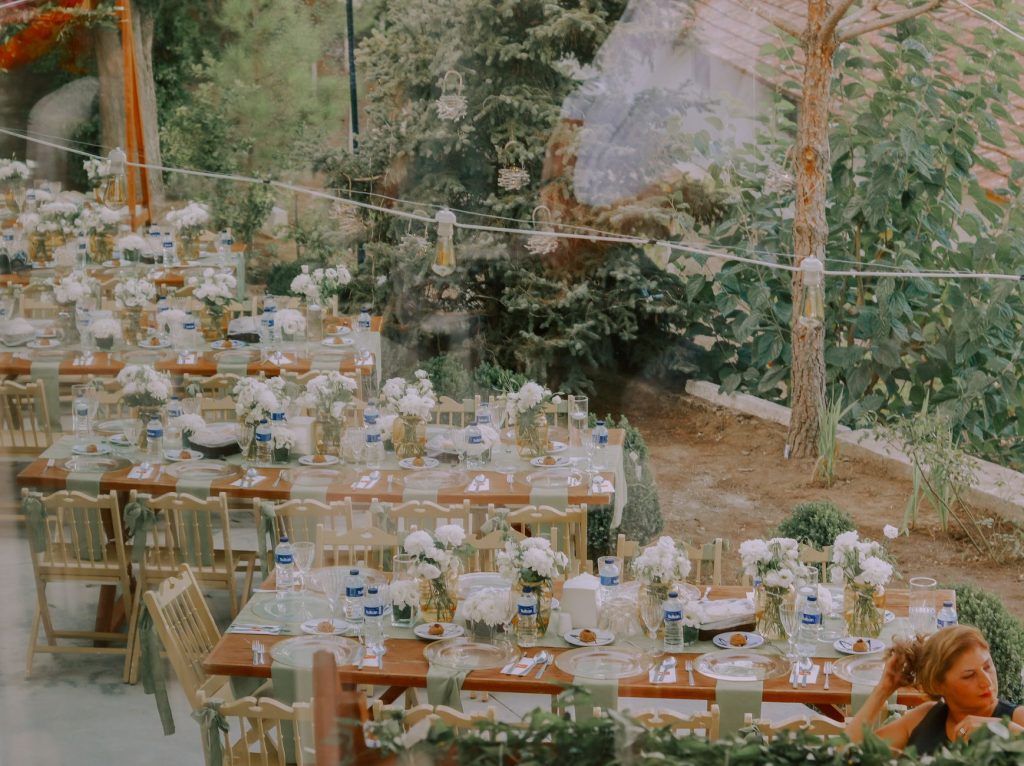 Elegant outdoor wedding reception with rustic wooden tables and floral decor.
