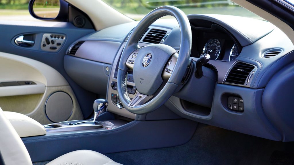 Догляд за салоном авто: чистота й свіжість надовго Elegant interior of luxury car featuring steering wheel and dashboard.