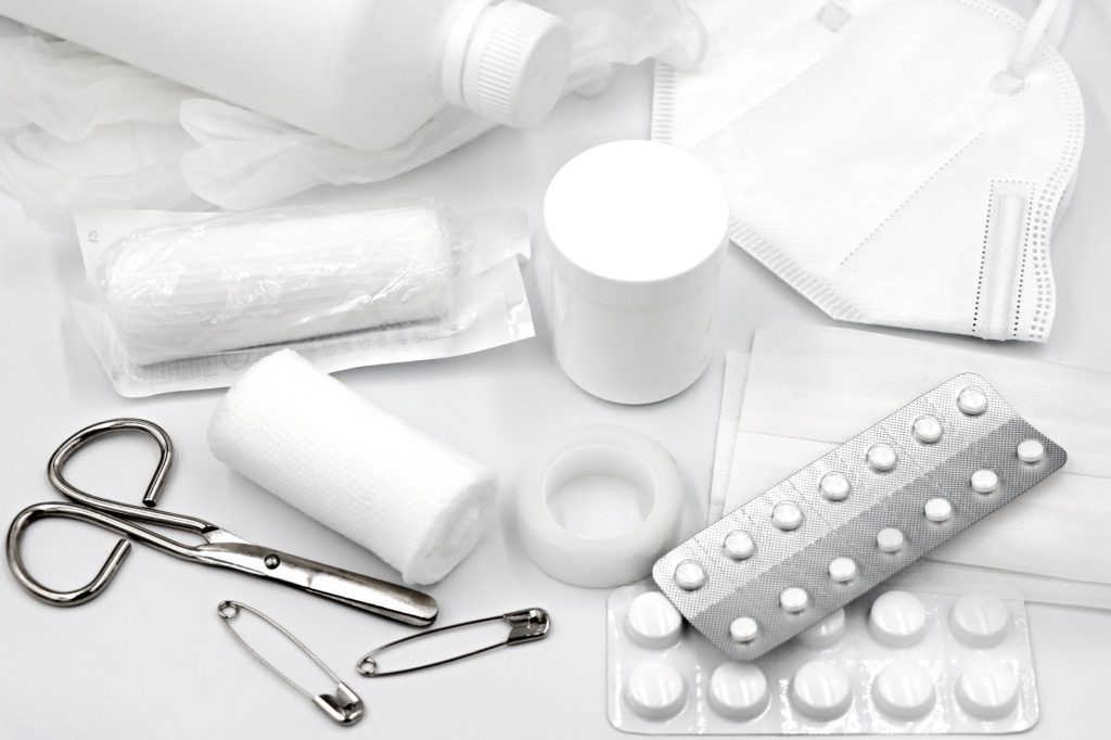 Домашня аптечка: що має бути в кожній родині A flat lay of essential first aid supplies and medical equipment on a white background.