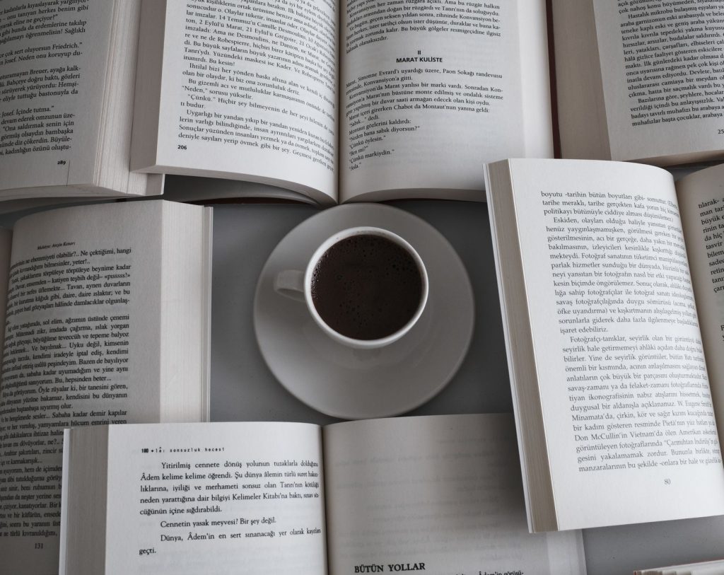 Як читати більше книг: звички, що справді працюють Relaxing setup with open books and a coffee cup, perfect for a serene reading session.