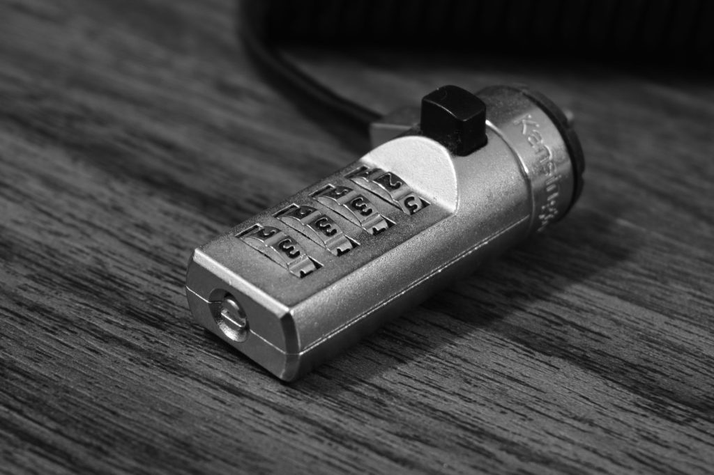 Як захистити персональні дані в інтернеті: практичні поради Black and white image of a metal combination lock on a wooden background.