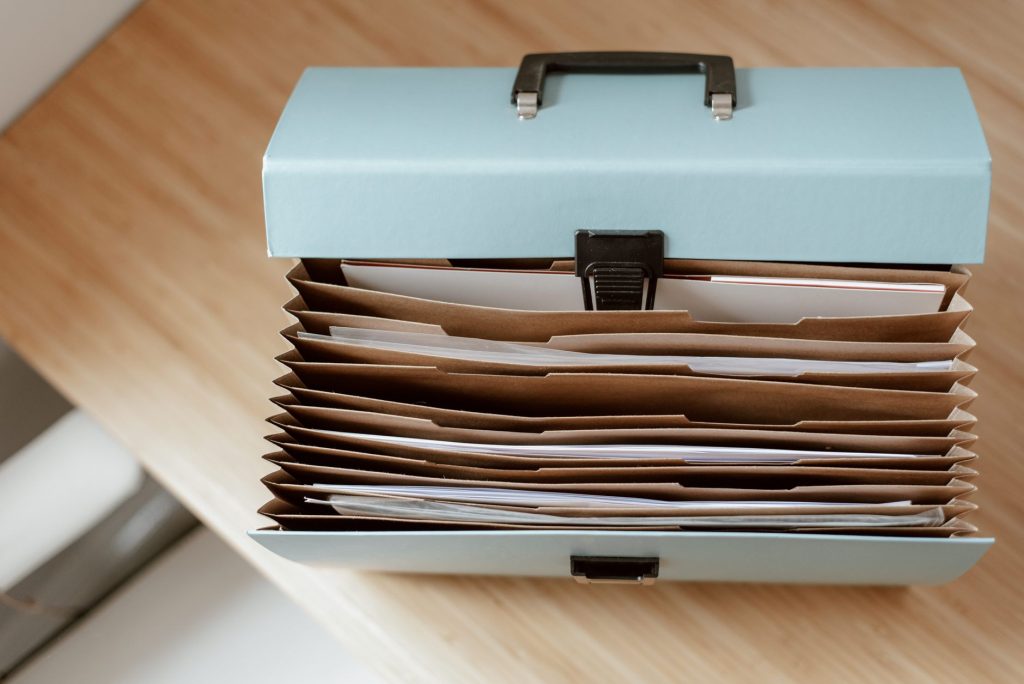 Як змінити КВЕД для ФОП онлайн: покрокова інструкція From above of briefcase for documents with papers placed on wooden table in daytime