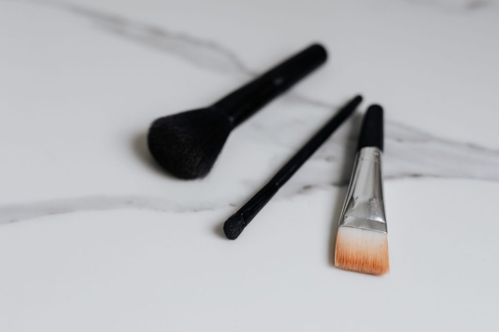 A variety of makeup brushes laid on a clean marble surface, showcasing elegance and style.